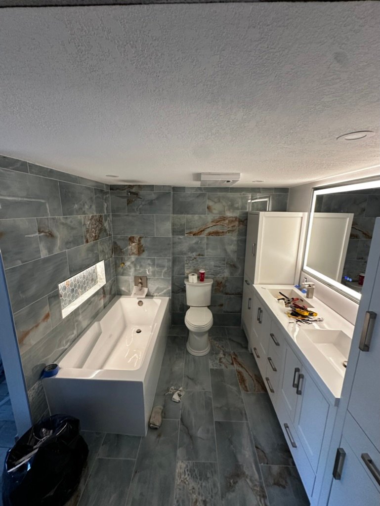 Bathroom lighting with an illuminated mirror and recessed ceiling lights